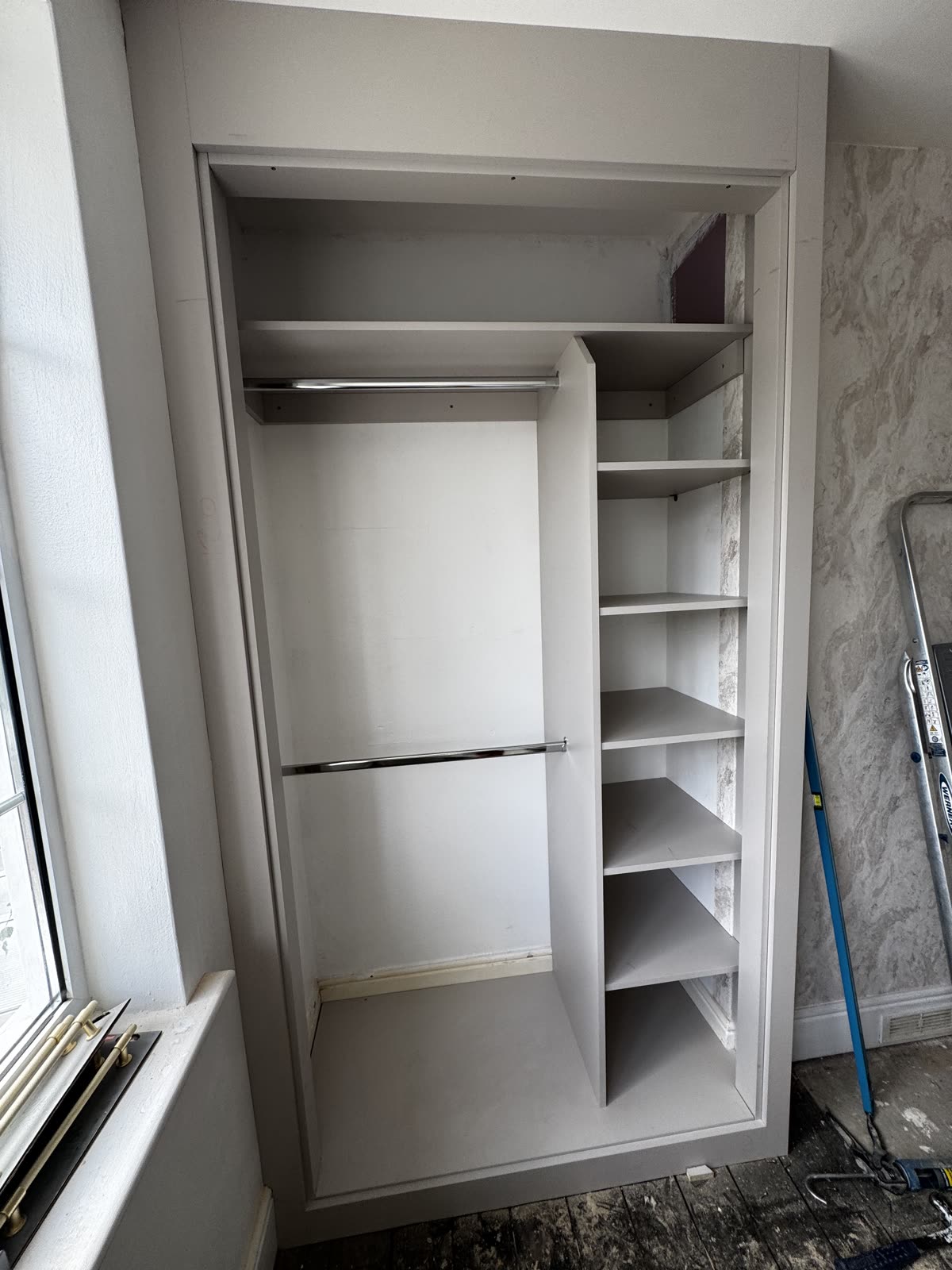 Inside an alcove wardrobe: double hanging rails and a full-height column of shelves, Kidderminster