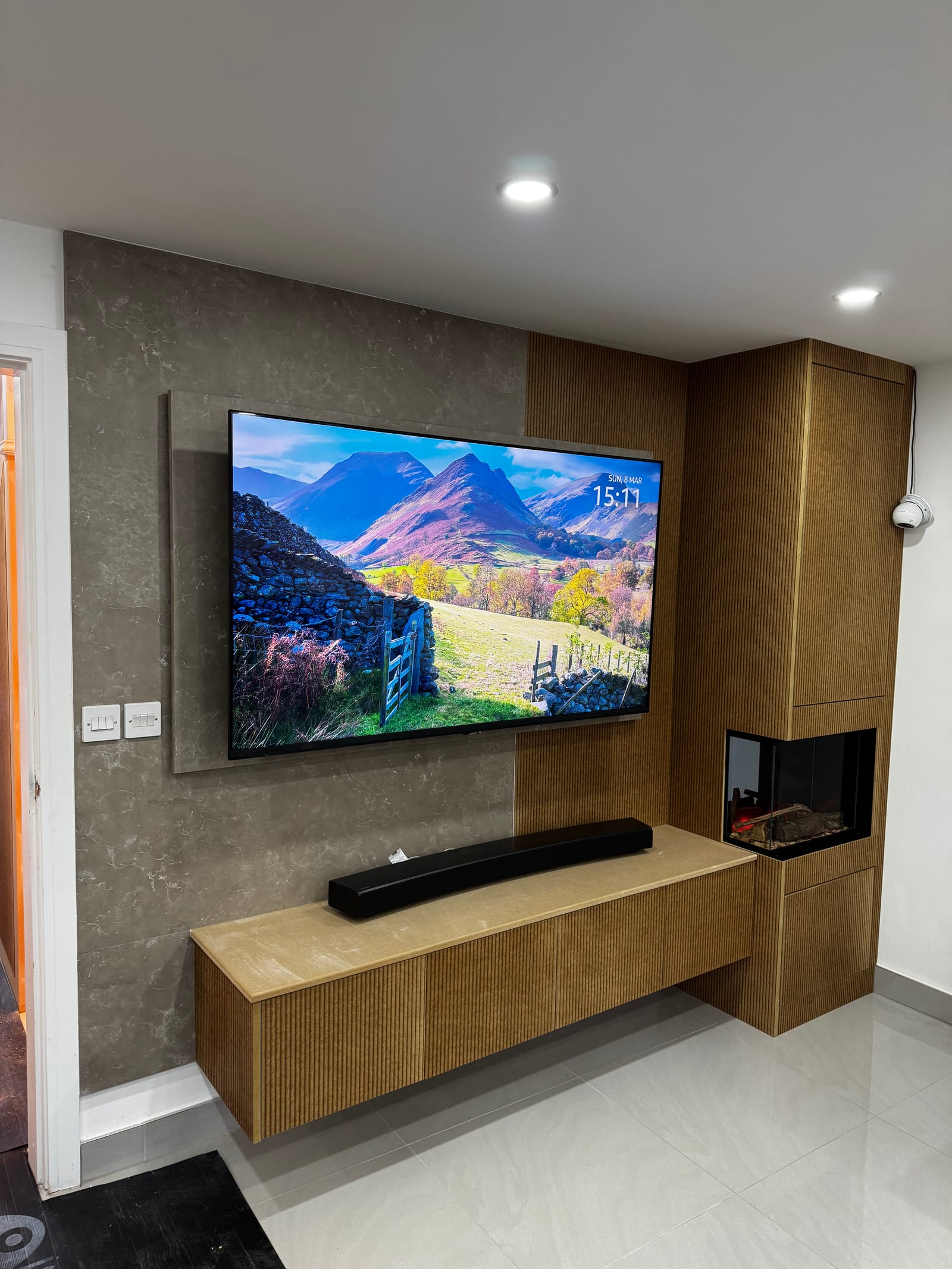 Bespoke bronze textured media wall with integrated screen and cabinetry