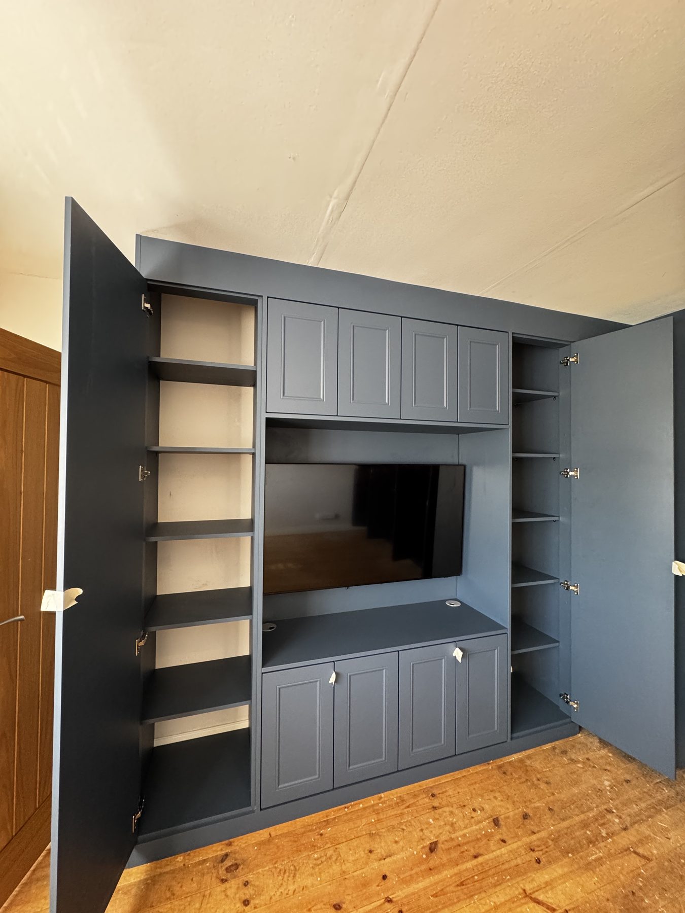 Bespoke media wall in Alby Blue with open shelving, panelled cupboards and integrated screen, Birmingham