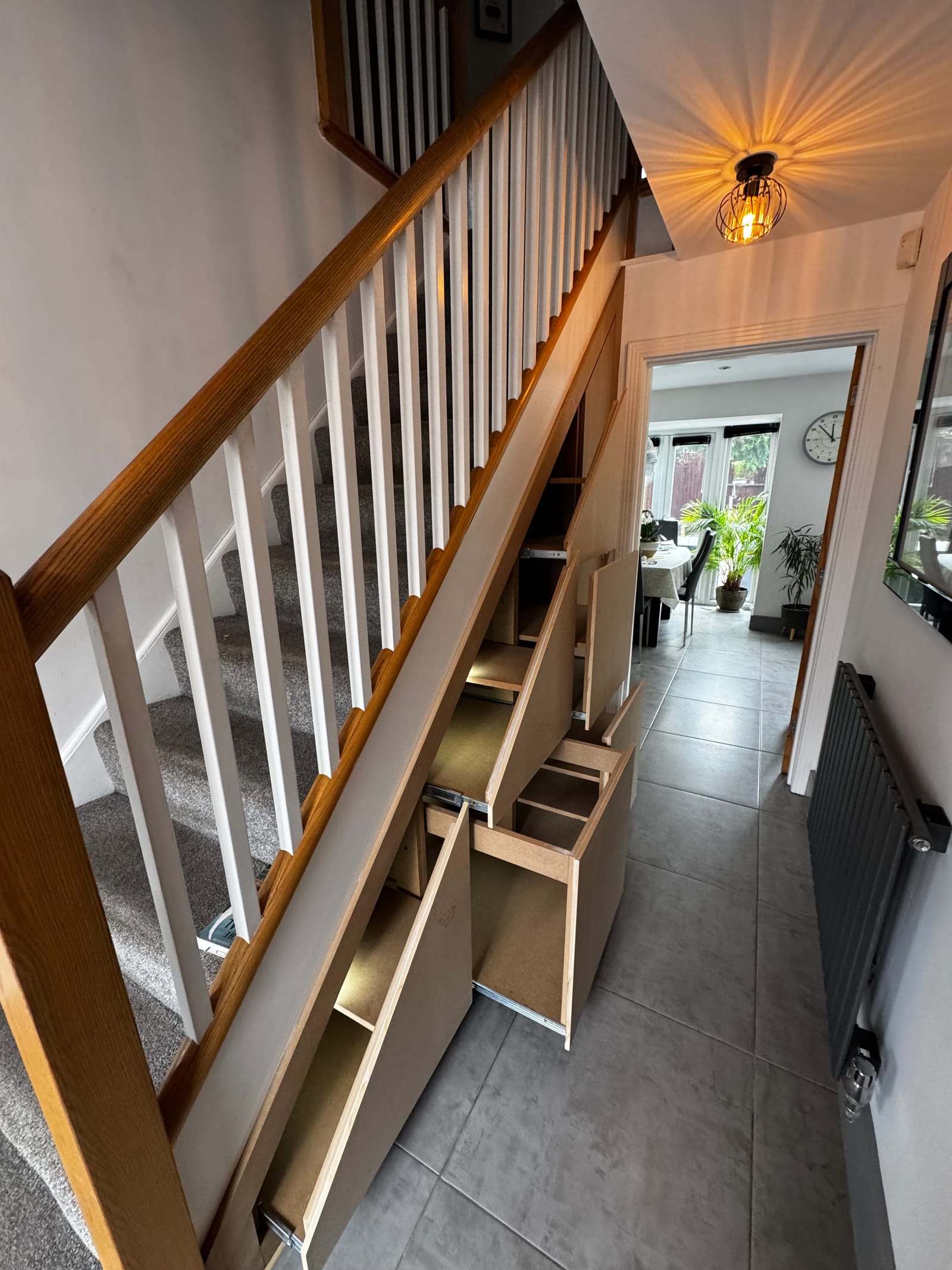 Bespoke open-side under-stair storage with glass balustrade, oak treads and asymmetric shelving
