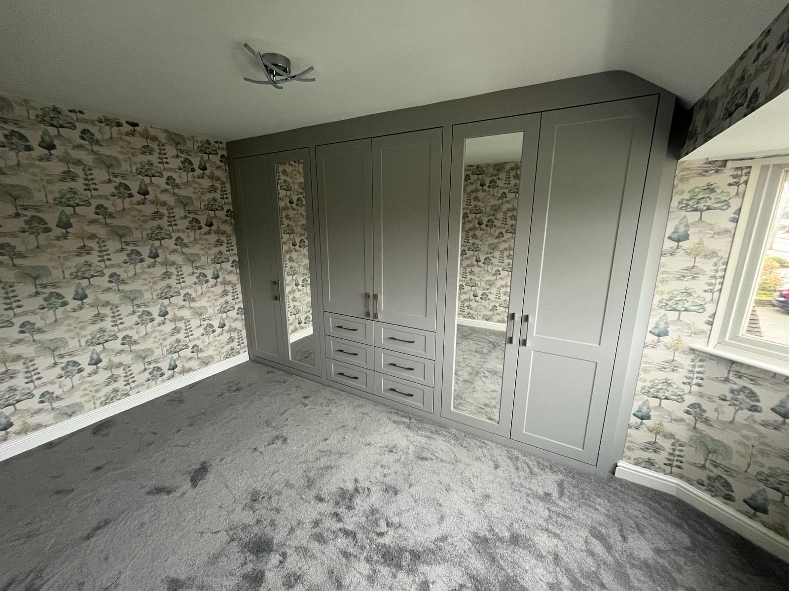 Grey shaker fitted wardrobe run with integrated drawers